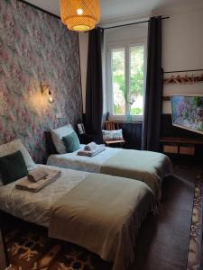 a room with two beds and a window at La Scierie in Quillan