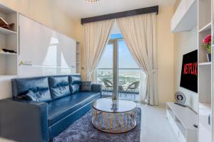 a living room with a blue couch and a table at 1514, Miraclz By Danube in Dubai