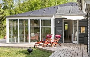 two chairs and an umbrella on a patio at 3 Bedroom Awesome Home In Ebeltoft in Ebeltoft