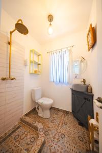 a bathroom with a toilet and a sink at Alunis Retreat in Aluniş