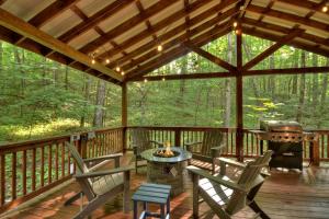 a screened in porch with chairs and a grill at K6 Lodge Gather around the firepit soak in the hot tub and splash in the creek in Blue Ridge