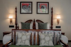 sypialnia z łóżkiem z dwoma drewnianymi słupami w obiekcie Aloof Jungle Lodge w mieście Ghānerao