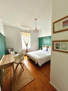 1 dormitorio con cama, mesa y escritorio en Appartements Plantagenet - Le 33, en Le Mans
