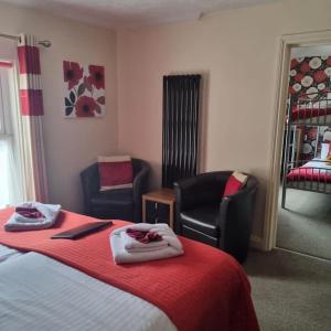 a hotel room with a bed and two chairs at The Fawley Guest house in Shanklin