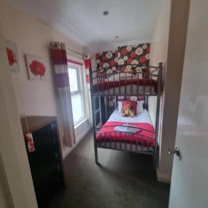 a bedroom with a bunk bed with a red blanket at The Fawley Guest house in Shanklin