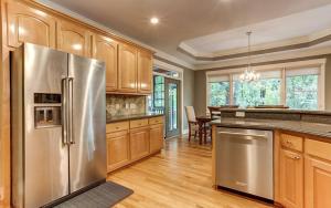 a kitchen with a stainless steel refrigerator and wooden cabinets at Wilderness Lodge - Fireside Chats Spa Baths in Afton