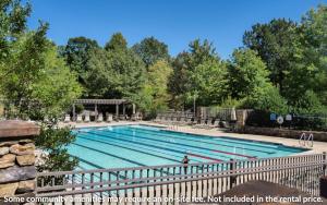 a large swimming pool with a fence around it at Treetopper Hideaway - A Relaxing Chic Bungalow in Marblehill