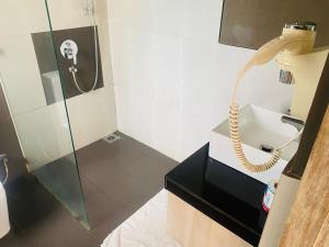 a bathroom with a shower with a phone on the wall at Hotel Cloud 9 Negombo in Negombo