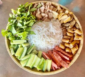 un bol lleno de diferentes tipos de verduras y fideos en Areca Bungalow, en Phong Nha