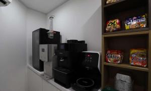 JECHEON No 25 HOTEL في Jecheon: غرفة مع آلة صنع القهوة وميكروويف