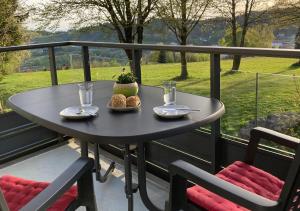 a table on a balcony with a table and two chairs at Bavarian Escape Ferienwohnung mit Pool in Sankt Englmar