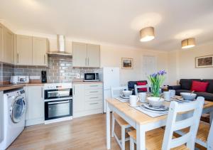 a kitchen and dining room with a table and chairs at The Cart Lodge in Chedgrave