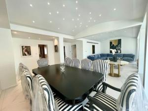 een eetkamer met een zwarte tafel en stoelen bij Penthouse Luxury Apartment in Nicosia