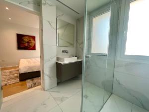 een badkamer met een glazen douche en een wastafel bij Penthouse Luxury Apartment in Nicosia +25 foto's