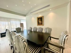 een eetkamer met een zwarte tafel en stoelen bij Penthouse Luxury Apartment in Nicosia