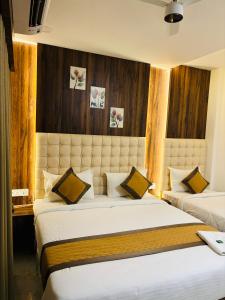 ein Hotelzimmer mit 2 Betten in einem Zimmer in der Unterkunft Hotel Relax Inn in Nagpur