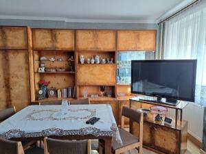 a living room with a table and a television at Haus in der ruhigen Siedlung in Sztum