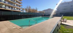 a swimming pool next to a building with a fountain at L'Ampolla, sol y mar in L'Ampolla +10 photos