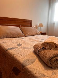 a bedroom with a bed with a quilt on it at Outes centro in Sierra de Outes