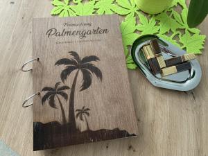 a book with a palm tree on it on a table at Ferienwohnung Palmengarten in Lichtenstein