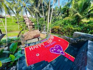 ein roter rangoli mit einem Happy Birthday Schild auf einem Garten in der Unterkunft Junjungan Suite in Ubud