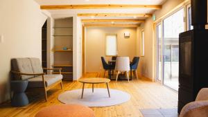 uma sala de estar com mesa e cadeiras em THE LIVIDA 軽井沢west コナラテラス em Karuizawa