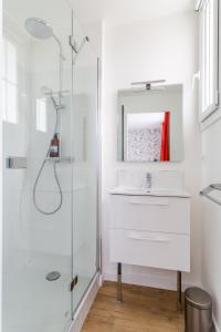 uma casa de banho branca com um lavatório e um chuveiro em Résidence MALO'INN - au cœur de Saint Malo em Saint Malo