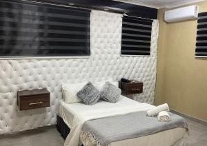 ein Schlafzimmer mit einem großen weißen Bett mit zwei Nachttischen in der Unterkunft Naldorado Executive Villa in Nelspruit