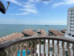 a balcony with a view of the ocean and buildings at Maison Seaview Suites Port Dickson in Port Dickson