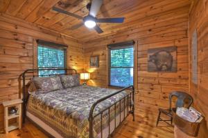 a bedroom with a bed in a log cabin at Bearfoot Ridge Wood-burning fireplace cozy hot tub serene views in Ellijay