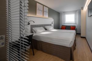 Hotel Bed4U Pamplona في Cordovilla: غرفة نوم بسرير كبير في غرفة