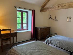 Schlafzimmer mit einem Bett, einem Schreibtisch und einem Fenster in der Unterkunft La Maison des Poètes 6 personnes à Treigny Perreuse in Perreuse