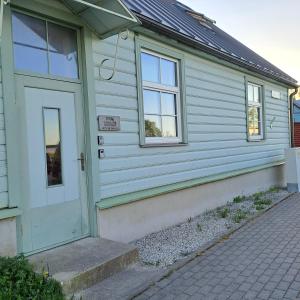 a white house with a door and windows at Tagalahe Apartment in Haapsalu