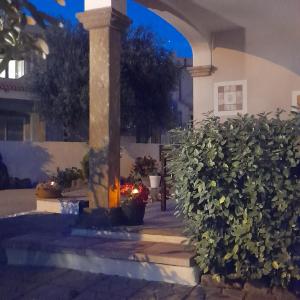 un porche de una casa con un pilar y arbustos en La Fortezza casa vacanze & appartament en Castelsardo