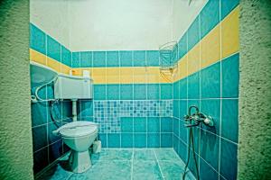 a blue tiled bathroom with a toilet and a shower at Elysee Cave House in Goreme