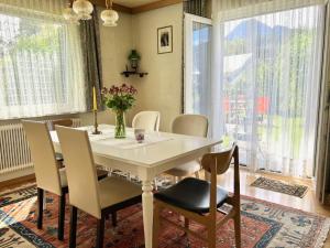 a dining room with a table and chairs and windows at Ferienhaus Faaker See 23 in Faak am See +33 photos