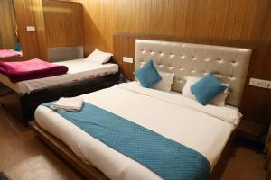 1 dormitorio con 2 camas y almohadas azules en Thesleepingbeautyhotel en Joshīmath