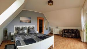 a bedroom with a large bed and a chair at Ferienwohnung Seeblick in Neu Schloen