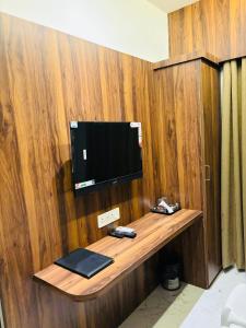 einen TV an einer Holzwand in einem Zimmer in der Unterkunft Hotel Relax Inn in Nagpur