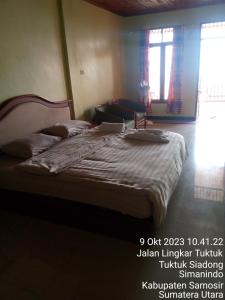 Un dormitorio con una cama con una computadora portátil encima. en Thenewgoldensunrise, en Tuk Tuk 4 fotos más