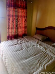 1 cama no hecha en un dormitorio con cortina en Thenewgoldensunrise, en Tuk Tuk