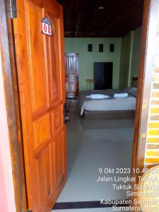 Una puerta abierta a un dormitorio con dos camas. en Thenewgoldensunrise, en Tuk Tuk