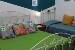 - une chambre avec 2 lits et des oreillers colorés dans l'établissement Casetta del Borgo, à Syracuse
