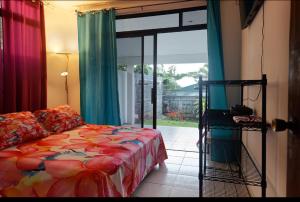 a bedroom with a bed and a sliding glass door at A TOMO MAI in Uturoa