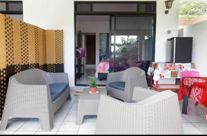 烏圖羅阿的住宿－A TOMO MAI，庭院配有白色藤椅和桌子