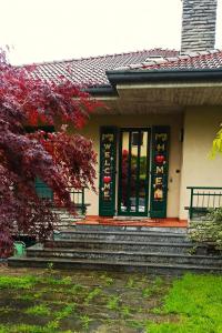 uma casa com portas verdes e escadas em frente em Villa Merone - Pusiano Lake em Merone