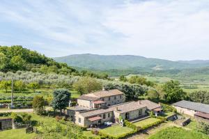 een luchtzicht op een huis met bergen op de achtergrond bij Apartment Marcigliana Front Pool Radicondoli, Siena in Radicondoli