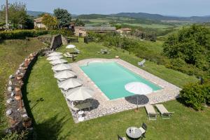 vista aerea su una piscina con ombrelloni di Apartment Marcigliana Front Pool Radicondoli, Siena a Radicondoli