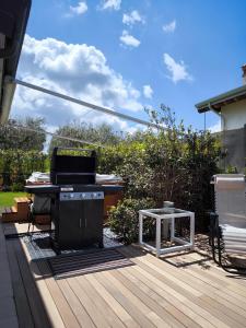 a grill on a deck with a table and a table at Villa Rita in Peschiera del Garda