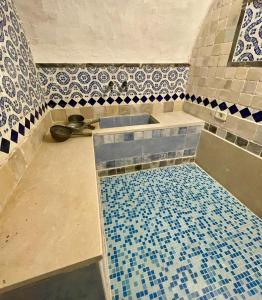 baño con lavabo y suelo de baldosa. en Dar Aziz en Sousse